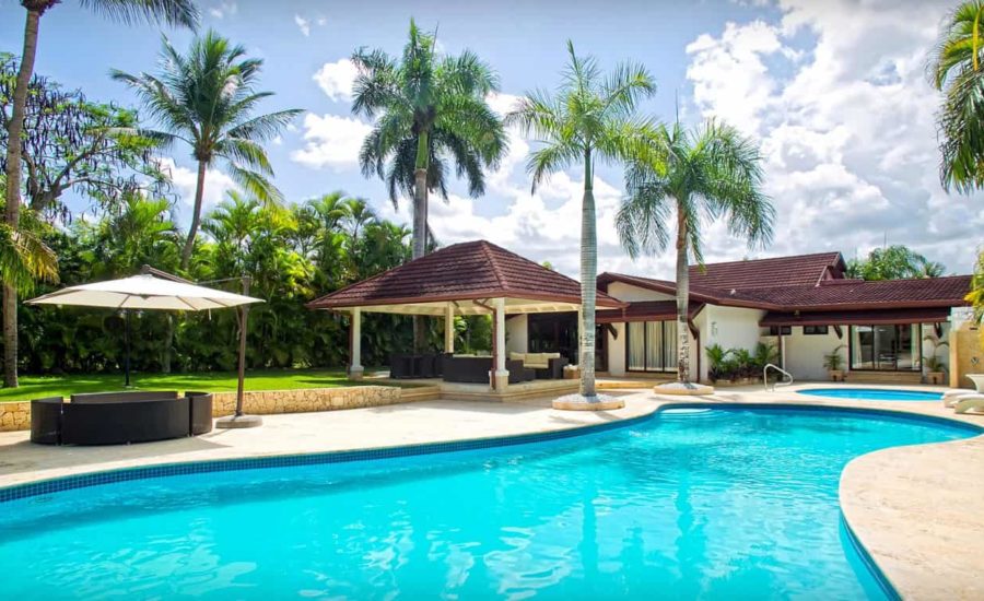 A private pool surrounded by palm trees at a rental villa in Dominican Republic.