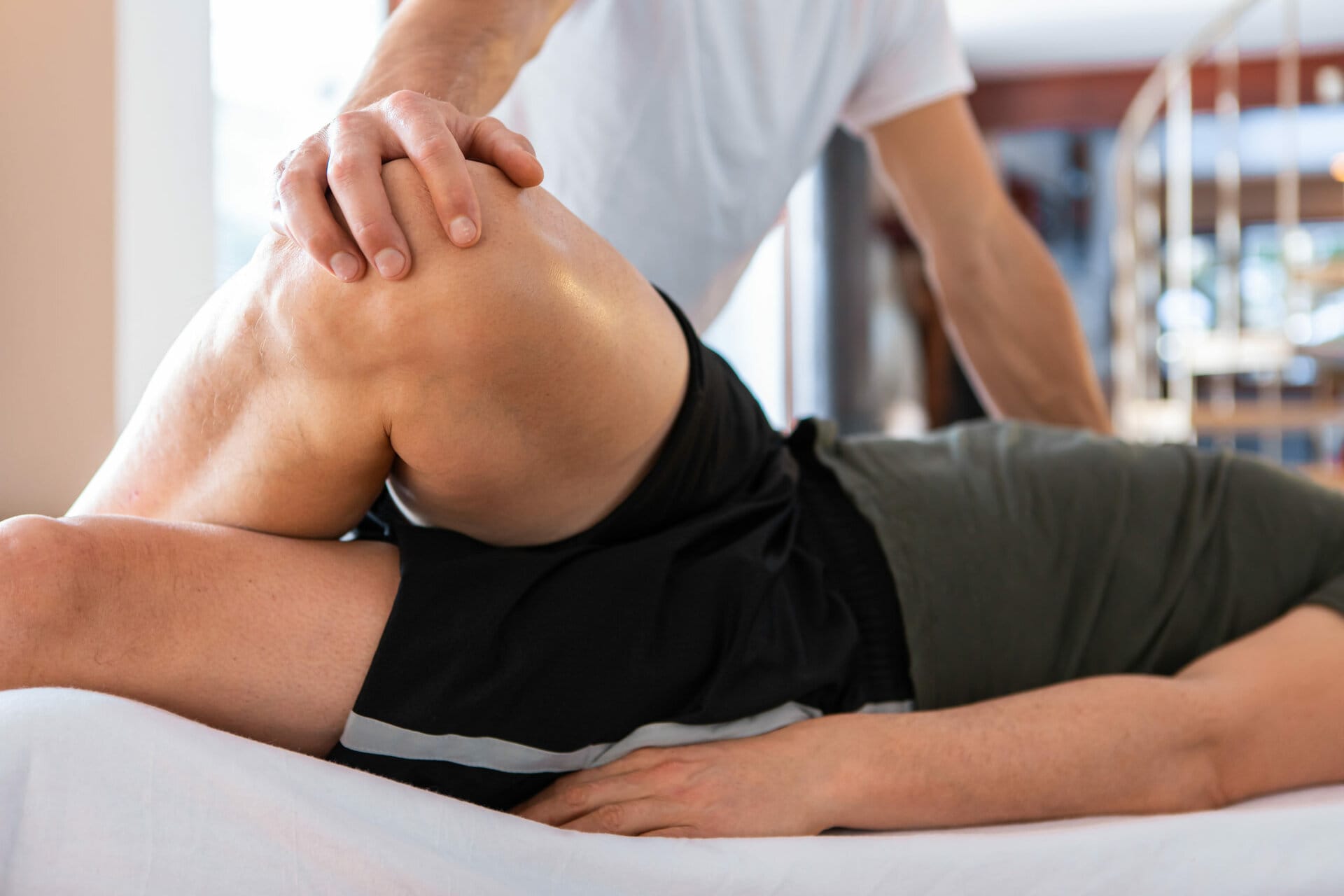 Sports physiotherapist massaging a client