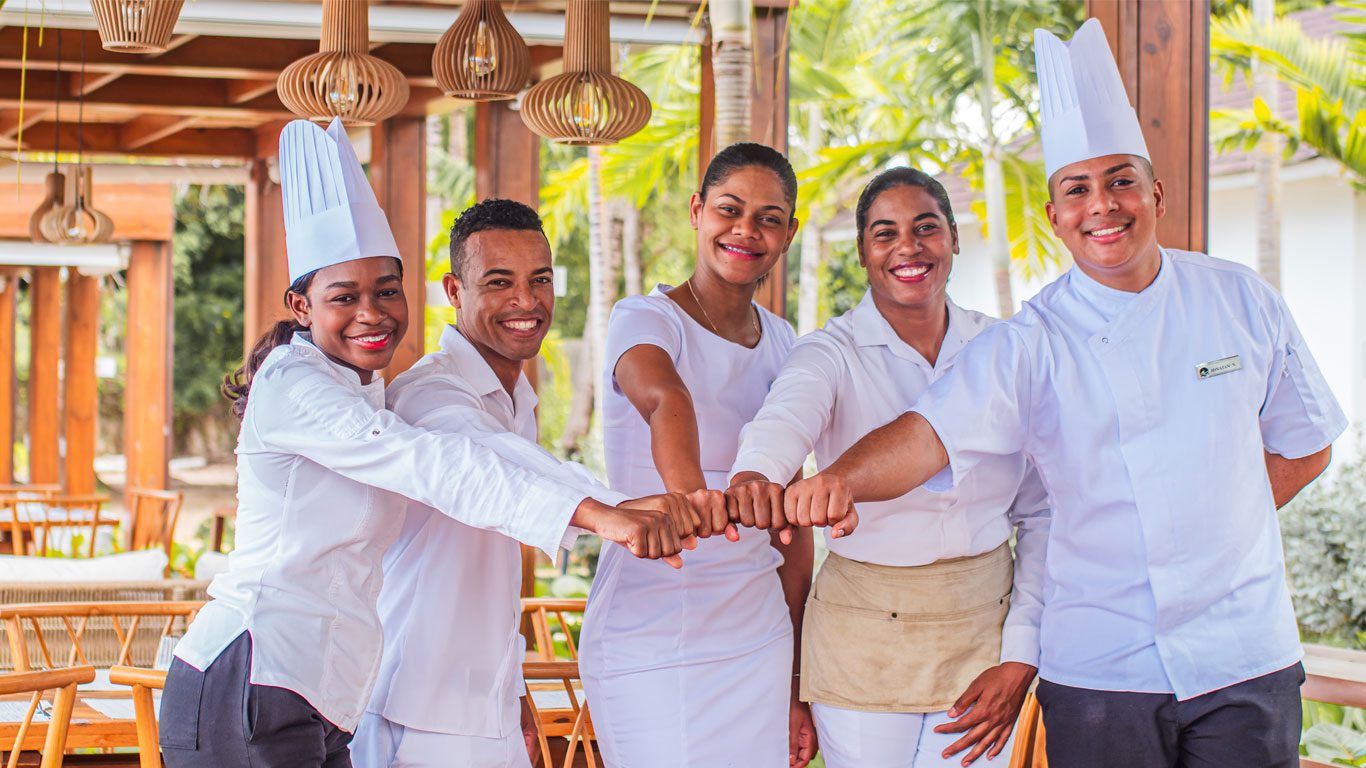 Group of Casa de Campo employees high-five | Great Place to Work
