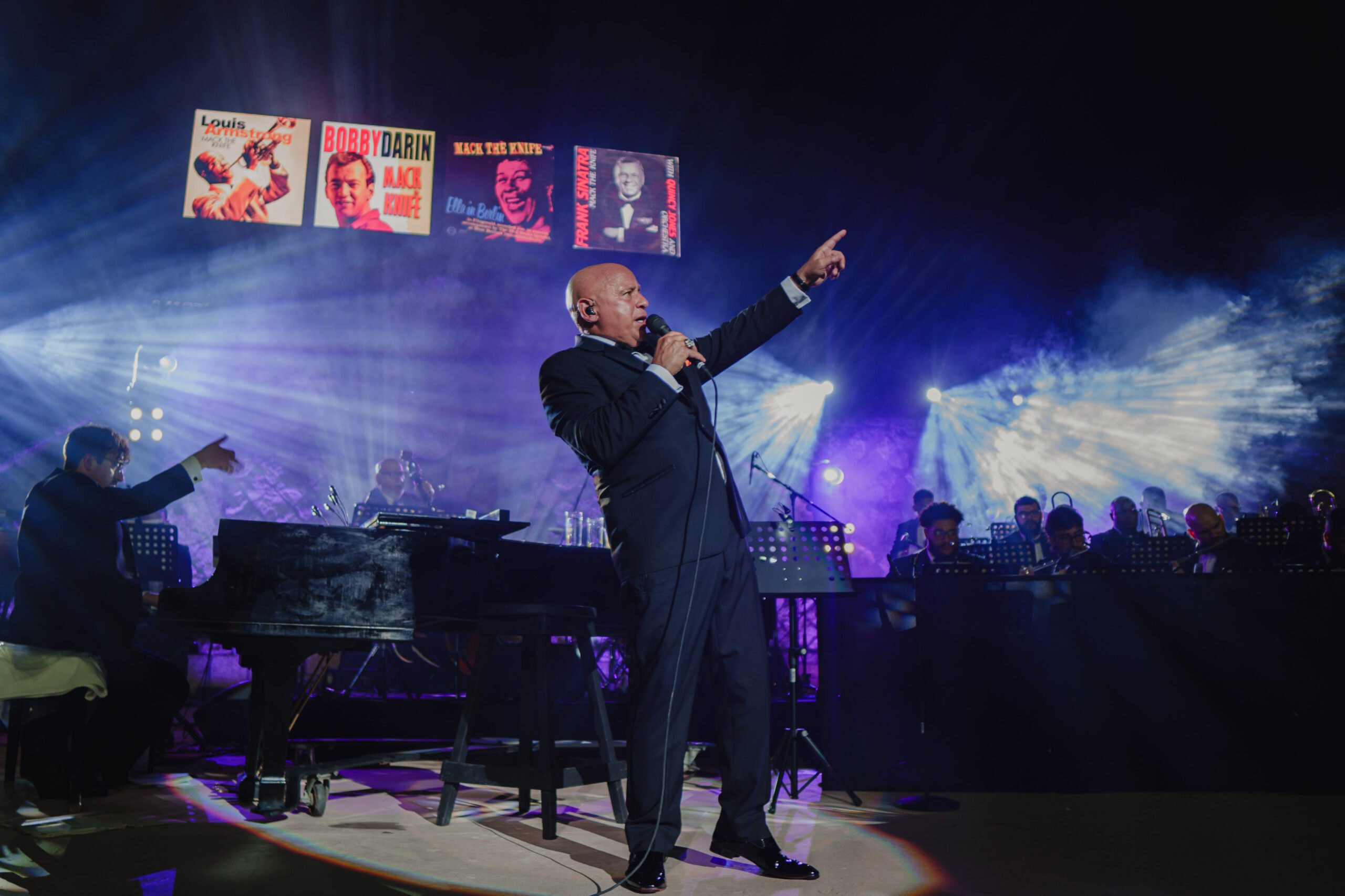 Michael Martocci performing on Altos de Chavón amphitheater with a microphone in hand